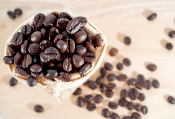 coffee bean in sack on plank wood background