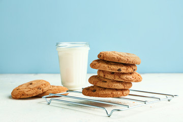 Tasty cookies with chocolate chips and glass of milk on table