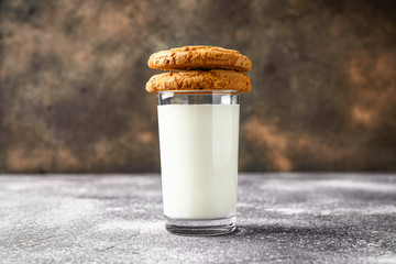 Tasty cookies with chocolate chips and glass of milk on table