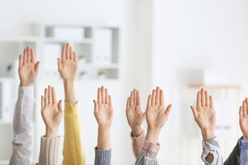 Hands of voting people indoors