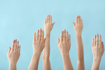 Hands of voting people on color background
