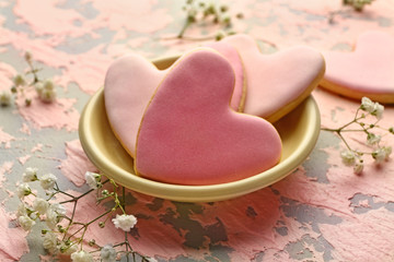 Plate with heart shaped cookies for Valentine's day on color background