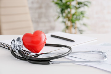 Stethoscope and heart on doctor's table. Cardiology concept