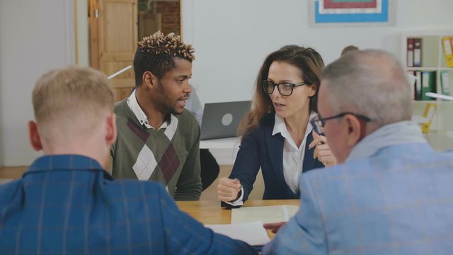 Successful business partners looking at each other during discussion of new plan