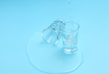 Vodka in shot glass on blue background with a blank space for a text, Russian vodka on color table