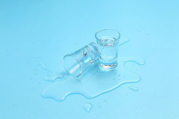 Vodka in shot glass on blue background with a blank space for a text, Russian vodka on color table