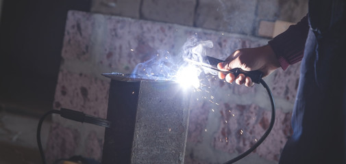 Welder performs welding work on metal.