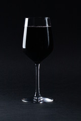 glass of red wine on black background