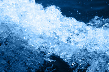 Classic blue 2020. Gradient color palette. Splashing waves on the water. Blue water background.