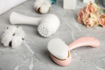 Plakat Modern face cleansing brush on light grey marble table. Cosmetic accessory