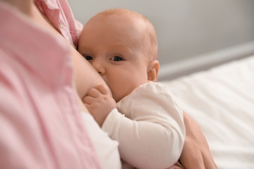 Young woman breast feeding her little baby, closeup