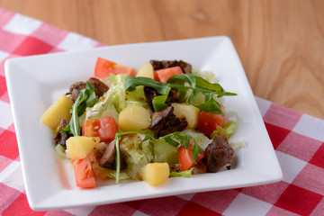 Healthy mix breakfast lunch dinner on a plate, potatoes, grilled meat, tomatoes, salad, sauce in cafe, restaurant.