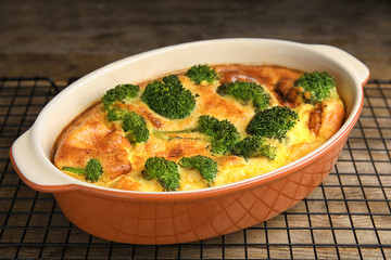 Tasty broccoli casserole in baking dish on cooling rack