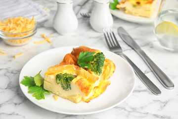 Tasty broccoli casserole served on white marble table