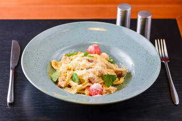 Traditional Italian pasta with cherry tomato, parmezan cheese and parsley served on white plate