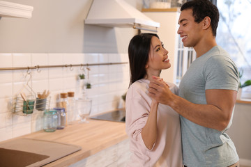 Fototapeta premium Lovely young interracial couple dancing at home. Space for text