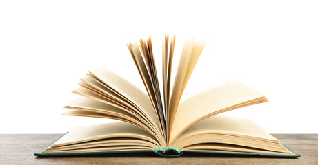Open book on wooden table against white background