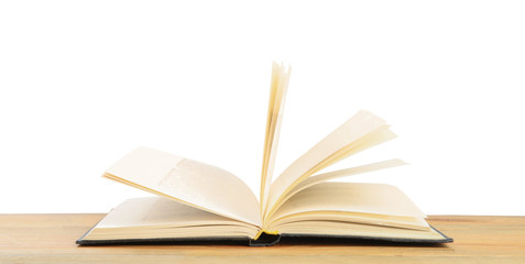 Open book on wooden table against white background