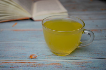 Workspace with tea on vintage wood with book in the background