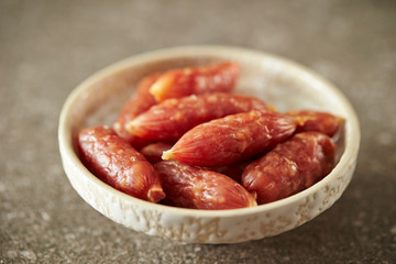 Small salami sausage on stone background 