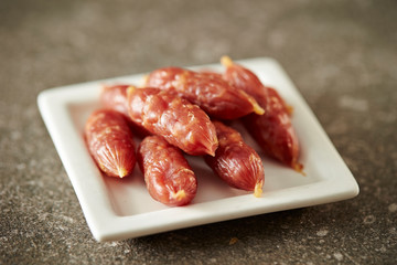 Small salami sausage on stone background 