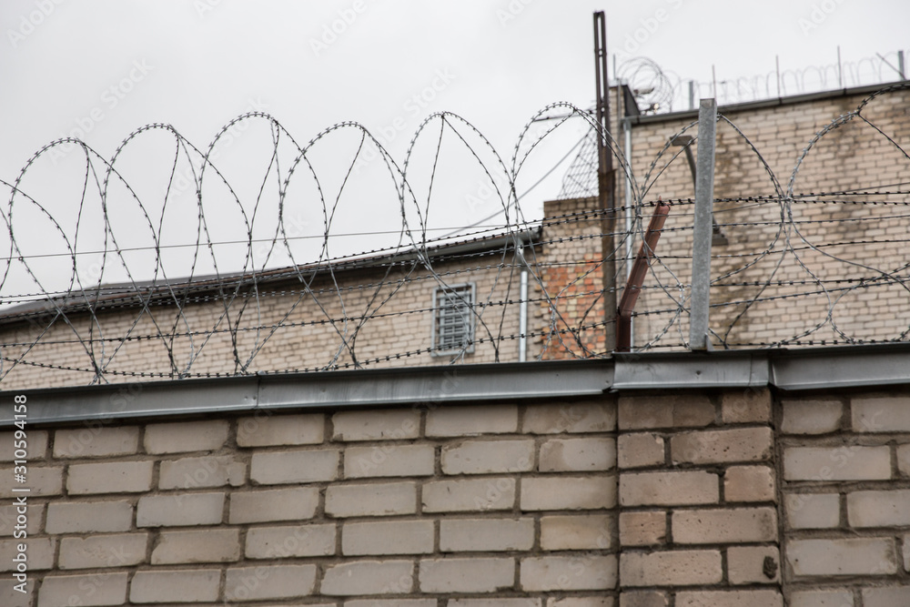 Wall mural prison or protected area. high brick walls with barbed wire.