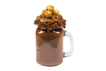 Chocolate milkshake with whipped cream, cookies, waffles, served in glass mason jar. 