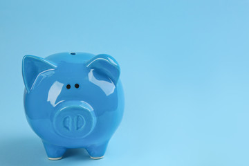Piggy bank on light blue background. Space for text