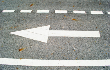 Fototapeta premium white arrow sign on asphalt road