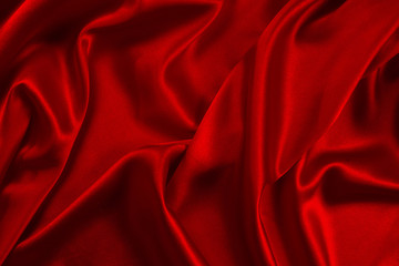 Red silk or satin luxury fabric texture can use as abstract background. Top view.