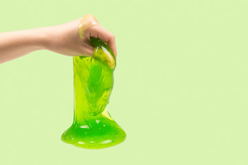 Green slime toy in woman hand isolated on white.