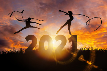 2021 New Year : Young gymnast woman dance ribbon silhouette performing rhythmic gymnastics on 2020...