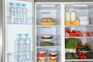 Open refrigerator full of different fresh products