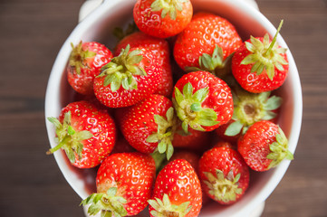 Homemade strawberries in a white plate close-up and copy space.