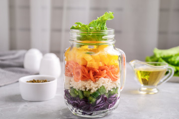 Healthy salad in glass jar on marble table