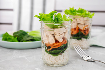 Healthy salad in glass jars on marble table