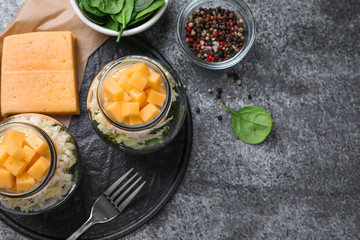Healthy salad in glass jars on grey table, flat lay