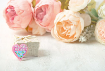 beautiful gentle greeting card with gift box, heart, pink flowers. concept of Valentine's day celebration, birthday, mother's day. image for your design. close up. soft selective focus