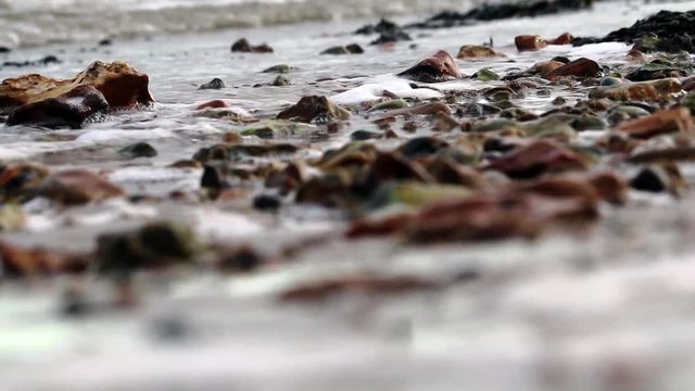 Close up of waves, pebbels on the beach