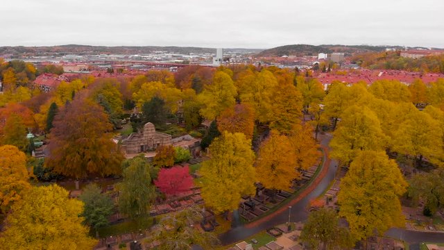 Aerial drone above Gothenburg graveyard, Sweden. Birds eye view of &ouml;stra Kyrkog&aring;rden cemetery with suburban view of red rooftops village. fall color trees over swedish scandinavian suburb neighborhood