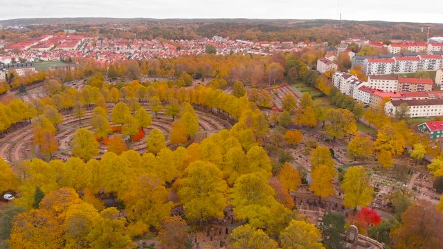 Aerial drone above Gothenburg graveyard, Sweden. Birds eye view of &ouml;stra Kyrkog&aring;rden cemetery with suburban view of red rooftops village. fall color trees over swedish scandinavian suburb neighborhood
