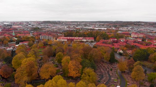 Aerial drone above Gothenburg graveyard, Sweden. Birds eye view of &ouml;stra Kyrkog&aring;rden cemetery with suburban view of red rooftops village. fall color trees over swedish scandinavian suburb neighborhood
