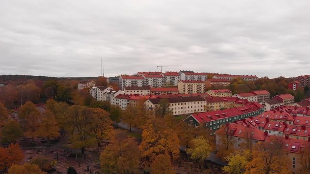 Aerial drone above Gothenburg graveyard, Sweden. Birds eye view of &ouml;stra Kyrkog&aring;rden cemetery with suburban view of red rooftops village. fall color trees over swedish scandinavian suburb neighborhood