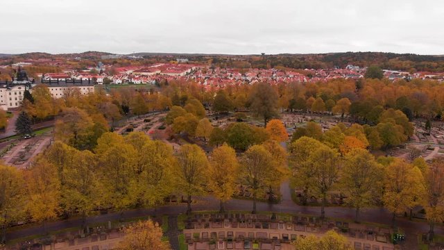 Aerial drone above Gothenburg graveyard, Sweden. Birds eye view of &ouml;stra Kyrkog&aring;rden cemetery with suburban view of red rooftops village. fall color trees over swedish scandinavian suburb neighborhood