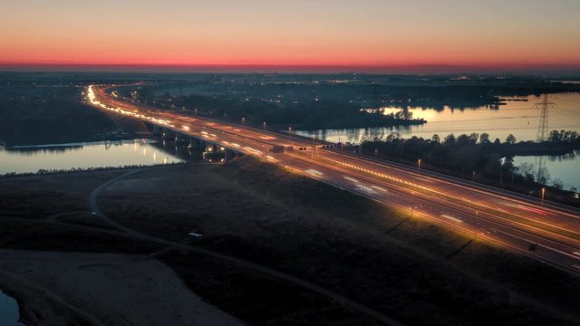 Evening traffic on the A6 highway that connects Amsterdam and the main land to the Flevoland polder with Almere and Lelystad cities in The Netherlands. Aerial timelapse/hyperlapse shot. 