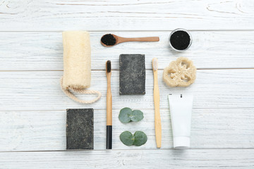 Flat lay composition with bamboo toothbrushes on white wooden table