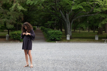 young woman in kimono walking in park