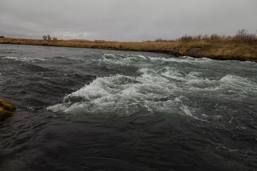 River and stunted grass on a dramatic landscape of Iceland.