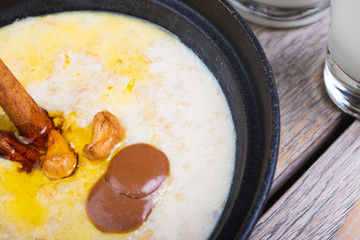 Traditional breakfast. Milk oatmeal with chocolate and granola. on a wooden table.