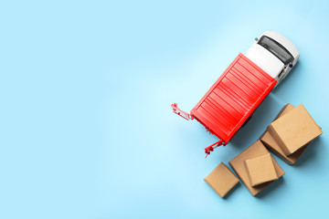 Top view of toy truck with boxes on blue background. Logistics and wholesale concept